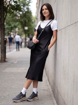 Cloudtilt Loewe – A mid-length black satin slip dress layered over a crisp white t-shirt, finished with a designer crossbody bag and minimal silver jewelry for a modern street-style vibe.