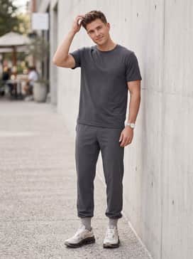 Slim-fit black performance shorts worn with charcoal grey compression leggings and a breathable, moisture-wicking technical tee for an active morning.