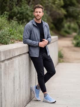 Cloudultra 2 – Technical black joggers with a tapered fit, worn with a slate grey merino wool base layer and a lightweight, packable windbreaker.