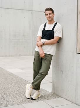 Cloudultra Pro – Olive green ripstop cargo pants with adjustable ankles, a boxy technical t-shirt in off-white, and a utility chest rig for a modern Gorpcore street-trail hybrid look.