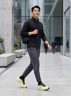 A sleek monochromatic black athletic ensemble featuring tapered performance joggers and a fitted charcoal quarter-zip pullover to let the lime yellow shoes stand out as a statement piece.