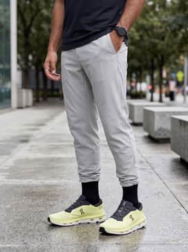 Slim-fit raw denim jeans cuffed at the ankle paired with a premium white t-shirt and an unbuttoned olive utility jacket for a refined weekend look.