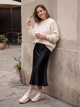 Style with a midi-length black satin slip skirt and a chunky-knit cream sweater to balance the sporty silhouette with feminine textures.