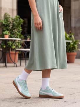 A sage green flowy midi dress that harmonizes with the mint upper, layered with a light beige cardigan for a soft, feminine daytime look.