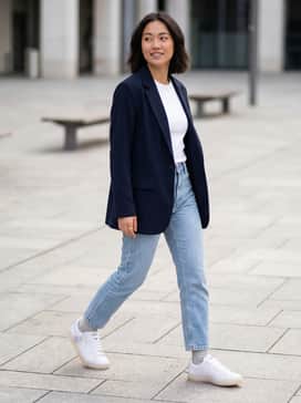 Light-wash straight-leg jeans with a tucked-in white baby tee and an oversized navy blazer for a polished yet relaxed aesthetic.