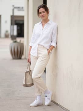 Clyde Club Las Vegas – High-waisted cream-colored chinos, a button-down linen shirt in a soft pastel, and a leather tote bag for a clean and airy weekend look.