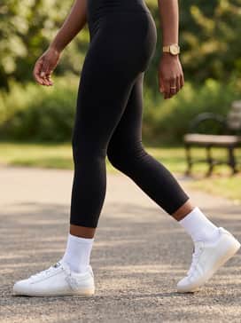 Cropped black leggings, an oversized graphic hoodie in a neutral tone, and white crew socks for a trendy athleisure vibe that highlights the sneaker's silhouette.