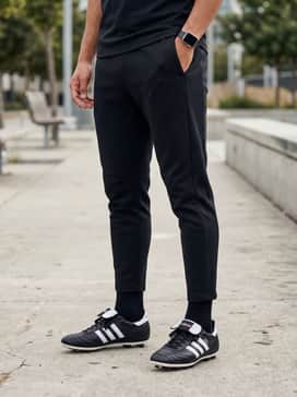 professional training look with a black tapered tracksuit, a lightweight tech-fleece quarter-zip, and low-profile performance socks