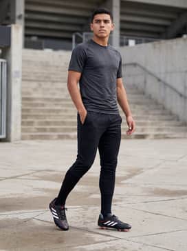 A high-performance training ensemble consisting of a dark grey compression base layer, a sleeveless black technical top, and fitted black 3/4 length training pants to allow for maximum leg mobility.