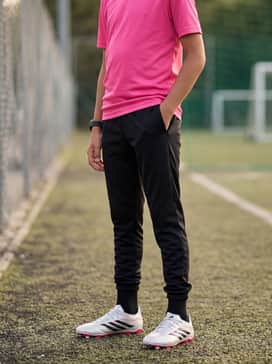 Copa Pure Iv Elite Firm Groundmulti Ground Soccer Cleats Kids – Black moisture-wicking training joggers paired with a bright pink athletic tee that echoes the shoe's outsole.