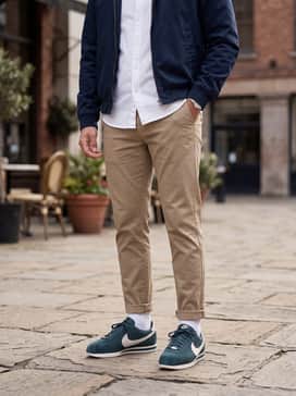 Cortez Premium – Khaki-colored slim-fit chinos worn with a crisp white button-down shirt and a navy blue Harrington jacket for a polished smart-casual aesthetic.
