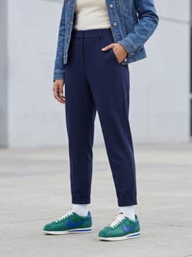 Cortez – Navy blue high-waisted joggers, a fitted cream-colored turtleneck, and a minimalist denim jacket for a clean athleisure look.