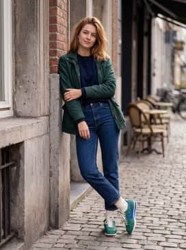 A cream-colored ribbed midi dress paired with a dark green bomber jacket to lean into a sporty-chic feminine aesthetic.