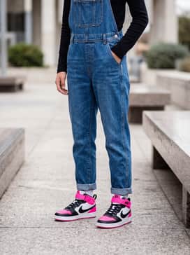 Classic blue denim overalls worn over a simple black long-sleeve tee for a durable yet stylish play outfit.