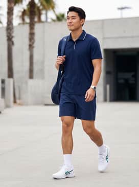 Court Ff 3 Novak – A navy blue performance polo with white piping paired with 7-inch inseam athletic shorts and white crew socks for a classic club-ready tennis look.
