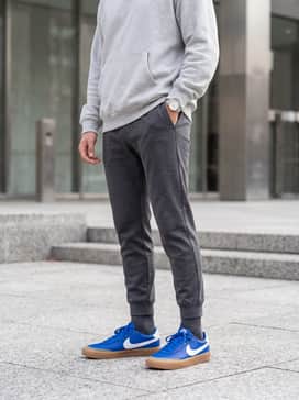 Match with tapered charcoal grey joggers and a light grey oversized hoodie to let the vibrant blue color pop against a neutral base.