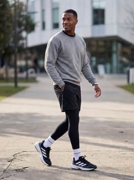 Lean into a monochrome aesthetic by styling the shoes with black athletic shorts, white crew socks pulled high, and a grey tech-fleece sweatshirt for a modern sporty silhouette.