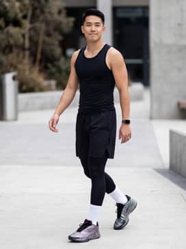 A pair of black moisture-wicking performance shorts paired with a compression tank top and white crew-length athletic socks for a professional court-ready look.