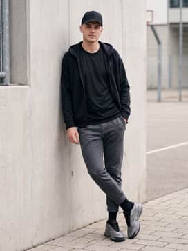 Crazy Energy Basketball Shoes – Dark grey slim-fit joggers worn with a sleek black hoodie and a structured baseball cap for a refined athleisure aesthetic.