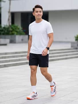 Crazyquick Padel Shoes – A high-performance court outfit featuring black moisture-wicking shorts, a crisp white tech tee, and white crew socks to highlight the shoe's orange accents.