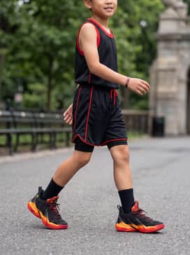 Curry 13 – A full team basketball uniform featuring black mesh shorts with red piping and a matching moisture-wicking jersey for a court-ready look.