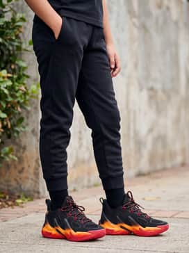 Curry 13 – Tapered black tech fleece joggers paired with a heather grey hoodie and a red snapback cap for a comfortable, sporty school outfit.