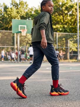 Curry 13 – Dark-wash athletic-fit denim or cargo joggers with a black windbreaker jacket and red crew-length athletic socks for a sharp streetwear vibe.