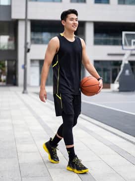 A black moisture-wicking basketball jersey with yellow detailing paired with matching black performance shorts and yellow crew socks for a court-ready look.