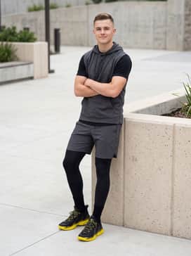 Curry 13 – Charcoal grey athletic training shorts worn over black compression leggings with a dark grey sleeveless hoodie for a modern, focused gym aesthetic.