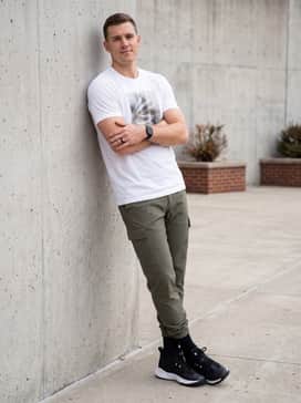 A streetwear-inspired outfit pairing the sneakers with olive green cargo pants, a white oversized graphic t-shirt, and a black beanie for a balanced urban aesthetic.