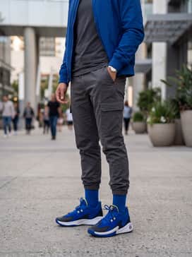 Curry 3z 25 Sde – A modern streetwear ensemble featuring black tapered cargo joggers, an oversized charcoal grey graphic t-shirt, and a royal blue nylon bomber jacket.