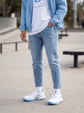 Combine with tapered light-wash denim jeans and an oversized white graphic tee featuring a minimalist blue design. Layer with a light blue nylon windbreaker for a cohesive, urban streetwear look.
