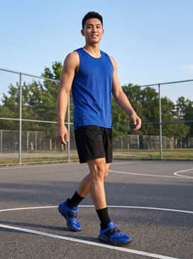 Black performance mesh shorts paired with a royal blue moisture-wicking jersey and black crew socks for a professional court-ready appearance.