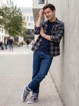 Daily 30 Shoes – Dark wash straight-leg jeans with a simple navy crewneck tee and an open flannel shirt in a grey and black plaid pattern.