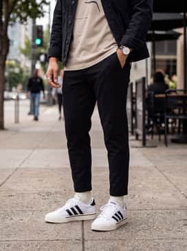 Daily 40 Shoes – A modern streetwear aesthetic with black tapered joggers, an oversized neutral-toned graphic t-shirt, and a layered denim jacket for a textured urban outfit.