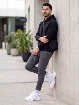 Dame Certified 3 Low Shoes – A modern athleisure outfit consisting of slim-fit charcoal joggers, a black technical fabric hoodie, and a sleek nylon crossbody bag.