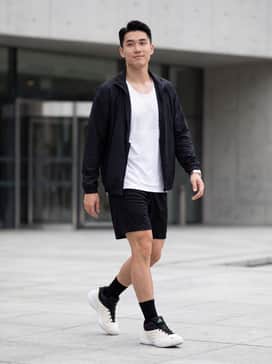 A high-performance court look featuring black mesh basketball shorts, a white moisture-wicking graphic tank, and black crew socks to accentuate the high-top collar.