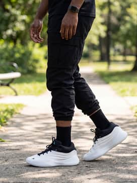 A utility-inspired aesthetic pairing black cinched-hem cargo pants with a crisp white oversized tee and a black cross-body utility bag for a functional vibe.