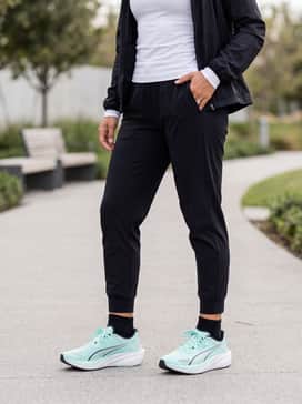 Darter Pro Tech Womens Sneakers – Black moisture-wicking joggers paired with a fitted white long-sleeve performance top and a lightweight black windbreaker for outdoor morning runs.