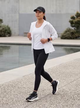 Deviate Nitro 3 – A sleek athletic ensemble featuring high-compression black leggings, a vibrant teal moisture-wicking tank top, and a lightweight white running jacket.