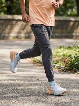 A high-intensity training outfit consisting of charcoal grey compression tights paired with a moisture-wicking peach-colored technical tee.