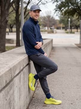 Dark navy tapered joggers styled with a silver-grey quarter-zip pullover and a breathable mesh running cap to complement the shoe's accent colors.