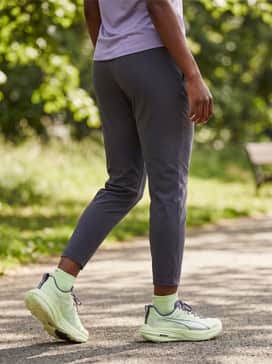 Dark grey tapered joggers, a violet performance-fabric tee, and a matching lilac running headband for a coordinated post-run look.