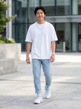 Light-wash tapered jeans paired with a crisp white oversized graphic tee and a silver chain necklace for a clean urban vibe.