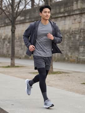 Moisture-wicking black running leggings paired with a breathable grey technical t-shirt and a lightweight windbreaker for early morning runs.