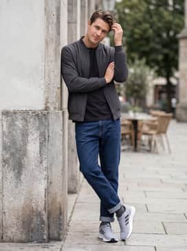 Dark wash athletic-fit jeans worn with a simple black graphic tee and a minimalist bomber jacket for a relaxed weekend outing.