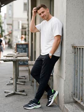 Street-Ready Athleisure: Style with black slim-fit track pants and an oversized white graphic tee to let the neon green accents of the shoe stand out.