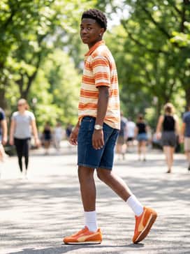 Denim shorts and a striped polo shirt featuring orange and cream stripes, paired with white crew socks for a playful, preppy summer vibe.