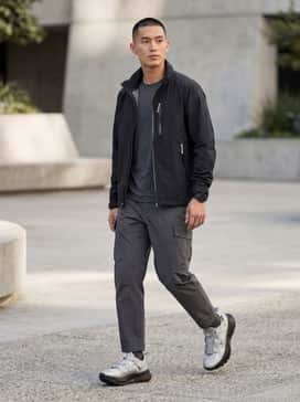 Equipment Agravic Xtr Shoes – A monochromatic techwear look featuring black tapered cargo joggers, a grey moisture-wicking base layer, and a black waterproof technical shell jacket with silver hardware.