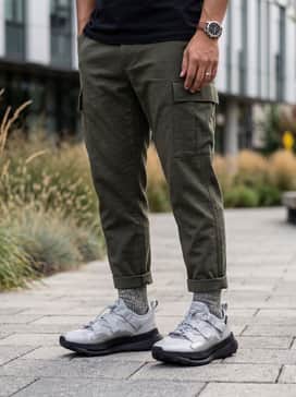 A rugged 'Gorpcore' ensemble with olive green utility trousers, a cream-colored heavyweight fleece pullover, and high-performance wool hiking socks visible above the ankle.